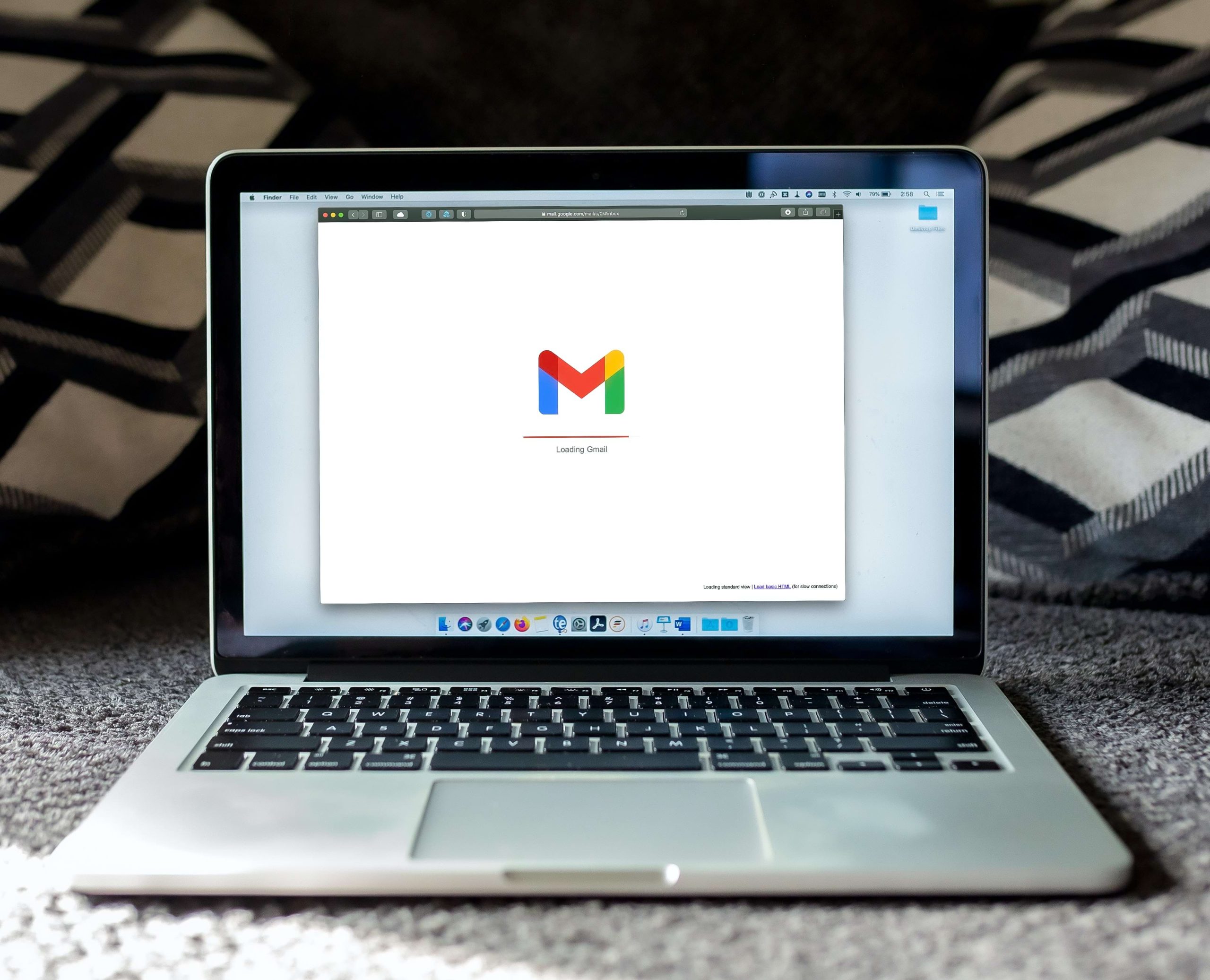 Logo của và biểu tượng đang đăng nhập Gmail xuất hiện giữa màn hình máy tính. 