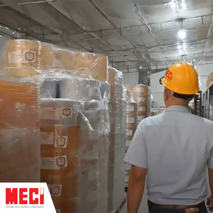 Một người kiểm tra kho hàng chứa đầy cuộn nhựa PVC