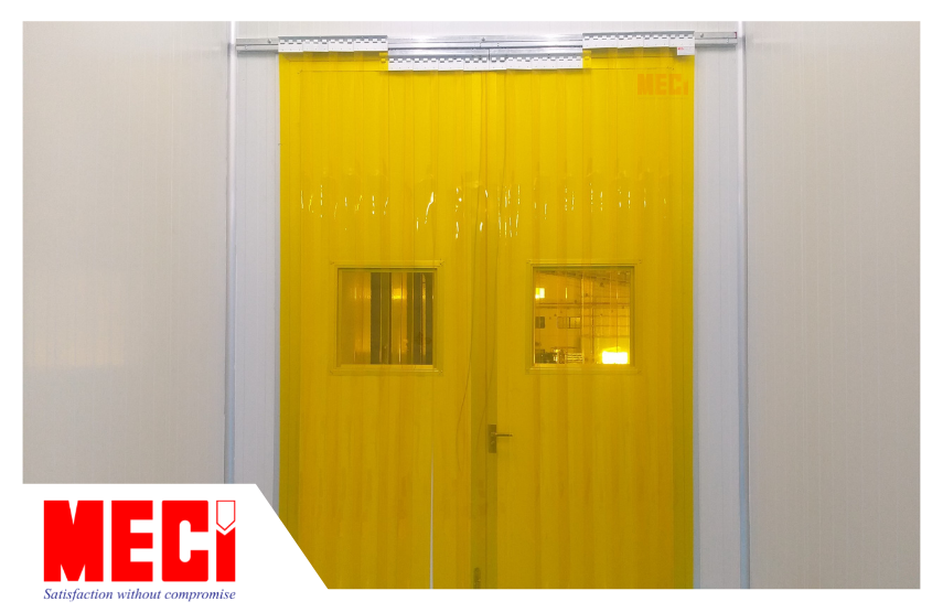 Rèm nhựa PVC ngăn côn trùng có màu vàng trong, lắp đặt tại cửa ra vào của kho xưởng. 