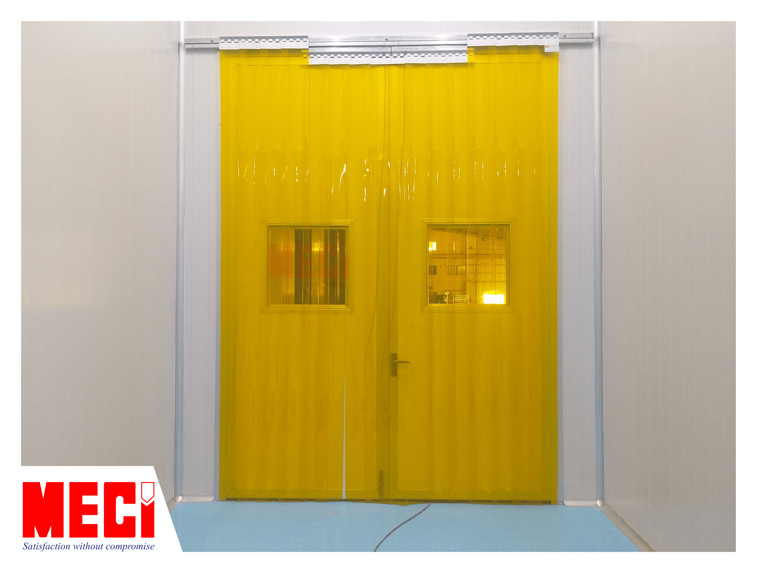 Rèm nhựa PVC màu vàng trong tại lối vào khu sản xuất, phía sau là cửa nhà máy