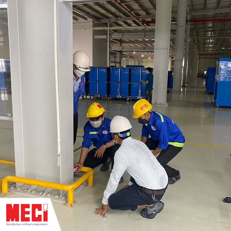4 anh nhân viên đang đo đạc kích thước để lắp cửa trong nhà xưởng