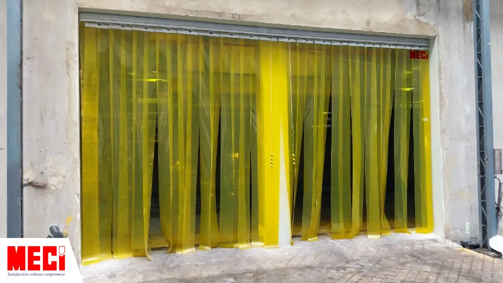 một lối ra vào lớn được phân cách làm 2 bởi 1 cái cột, được lắp đặt rèm nhựa PVC màu vàng dạng sợi