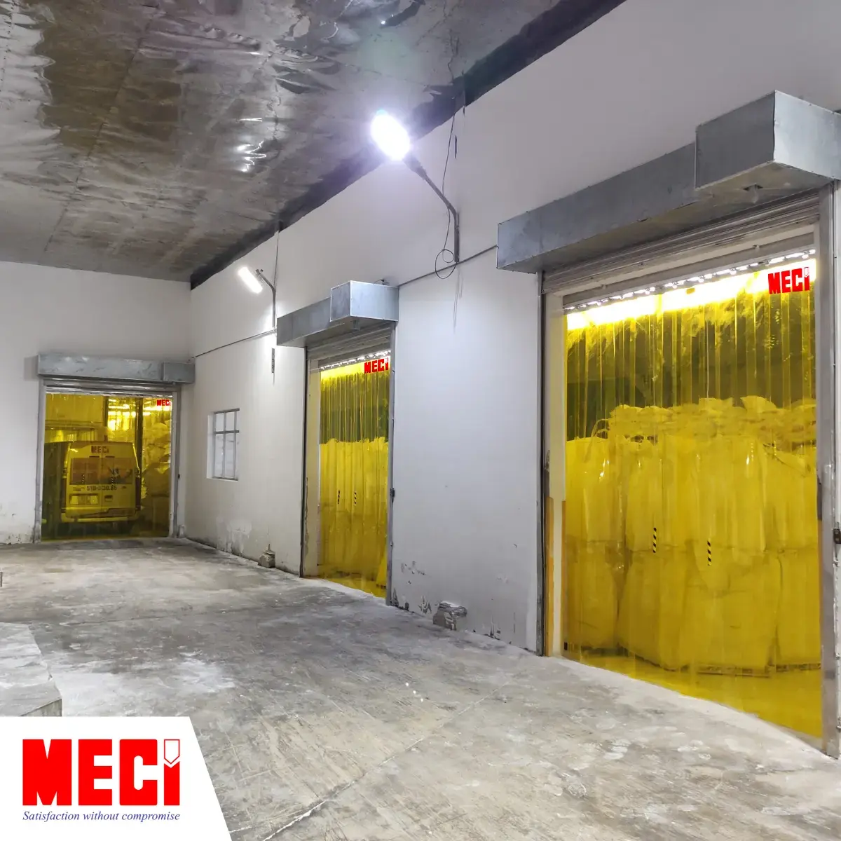 3 lối ra vào của một nhà kho được lắp rèm nhựa PVC màu vàng, bên trong kho có nhiều hàng hoá