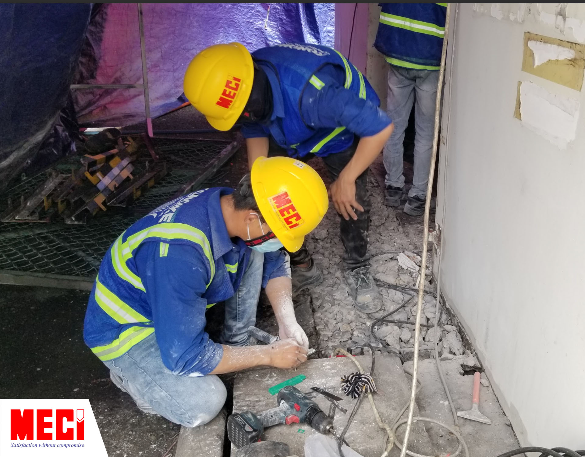hai kỹ thuật viên nam đang xem xét cái nền nhà đã bị khoan đục