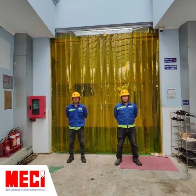 hai nhân viên MECI đứng trước rèm nhựa PVC màu vàng