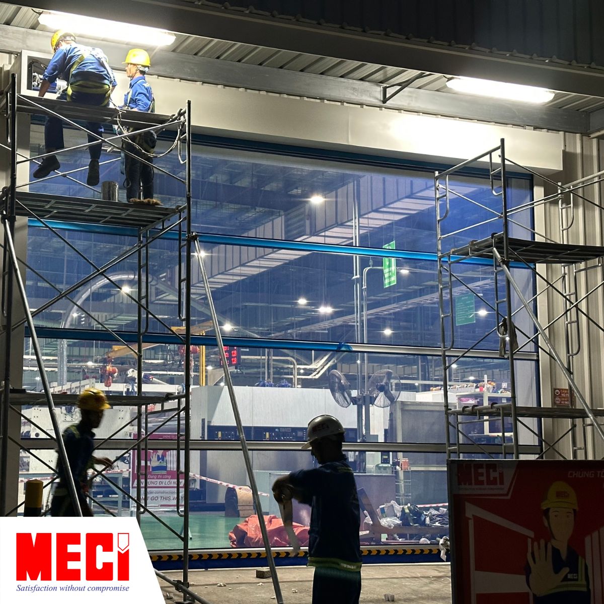 kỹ thuật MECI dang thi công cửa cuốn dạng lưới cho nhà máy bao bì