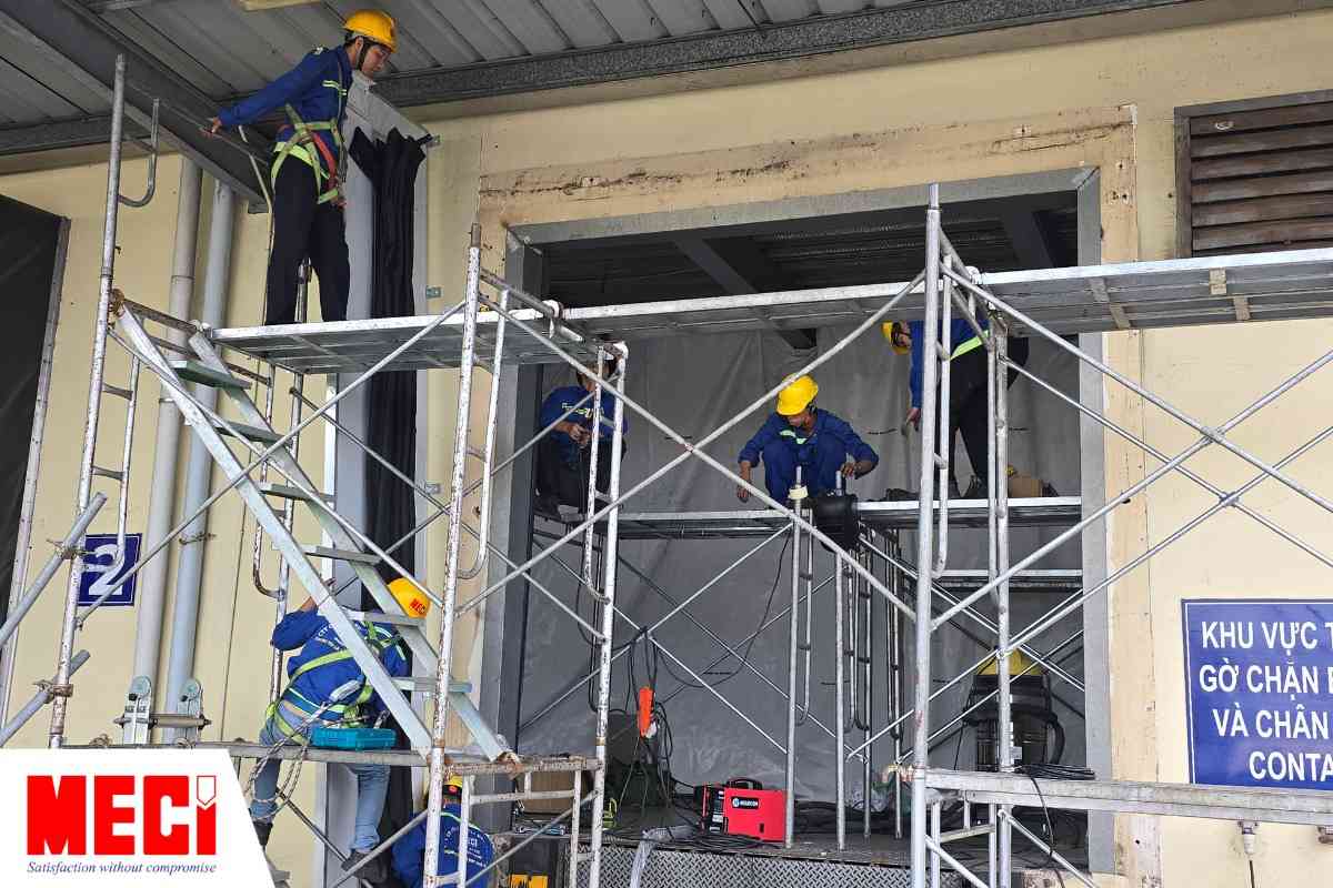 Kỹ thuật viên của MECI đang lắp đặt cửa trượt trần và bộ trùm túi khí cho nhà máy Olam Long Bình